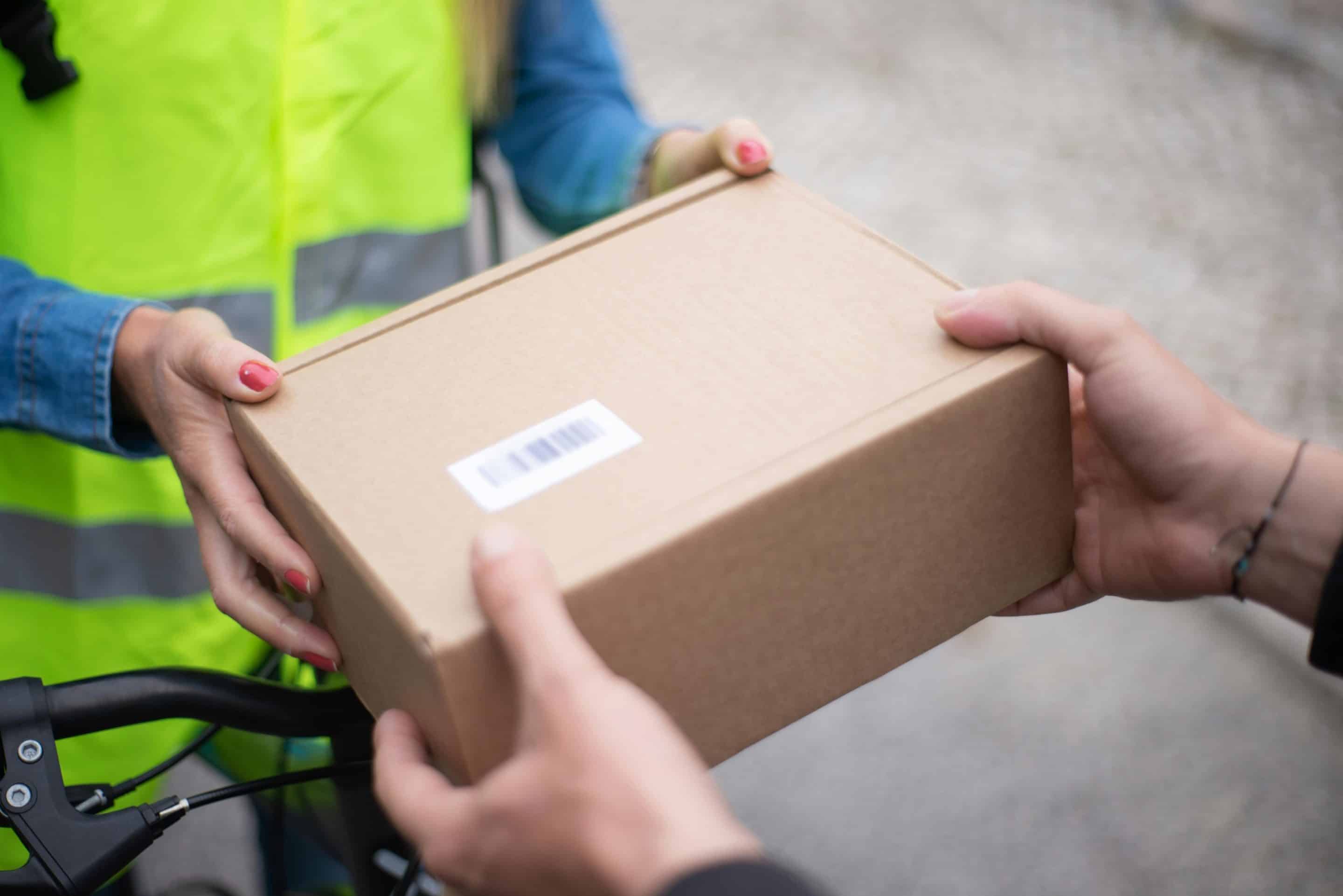 a-person-holding-brown-cardboard-box